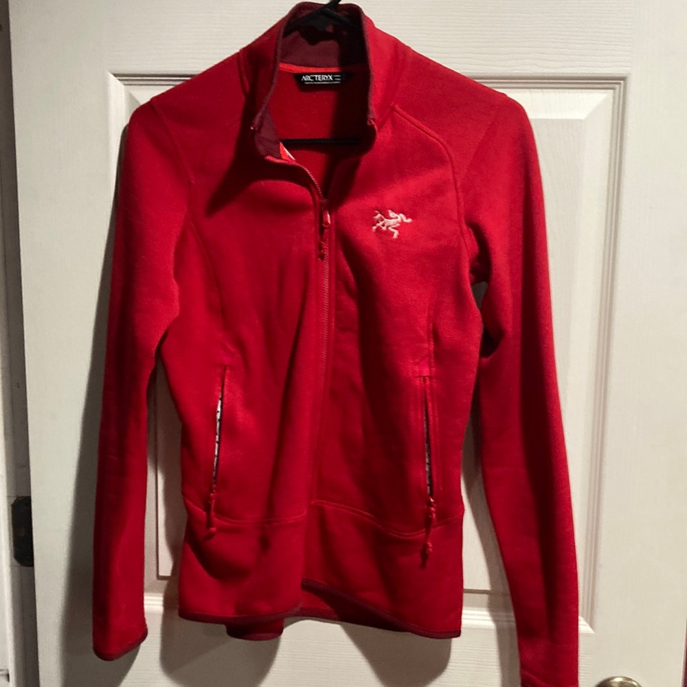 Red Arc’teryx lightweight full zip jacket.  Size XS.  Two large pockets.